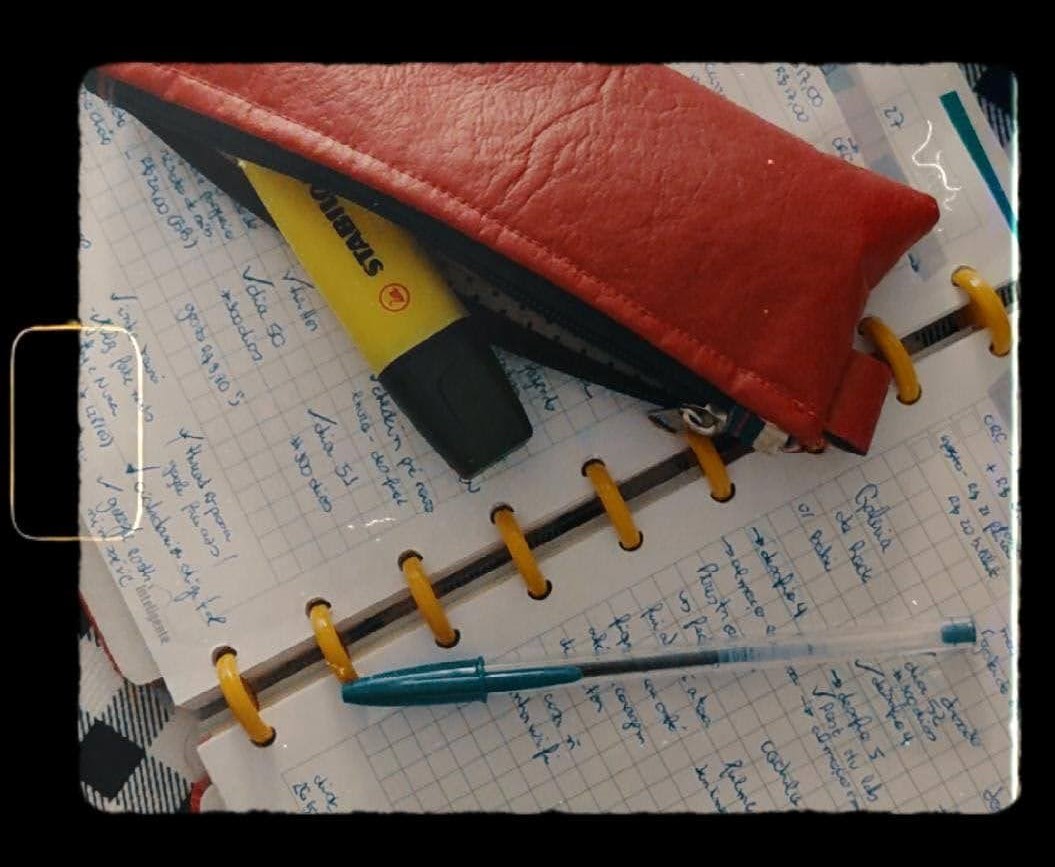 uma foto com efeito de filme antigo mostrando um pedaço da minha agenda, uma caneta e grifa texto jogada por cima 